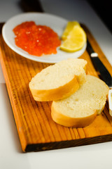Closeup on person eating red caviar delicacy from white plate, closeup light macro background
