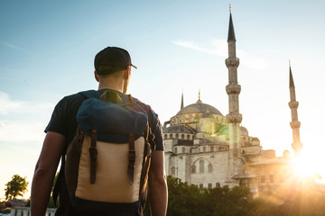 A man in a baseball cap with a backpack next to the blue mosque is a famous sight in Istanbul....