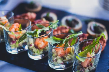 Foto op Plexiglas Gedecoreerde catering-bankettafel met verschillende hapjes-assortimenten op een feest © tsuguliev