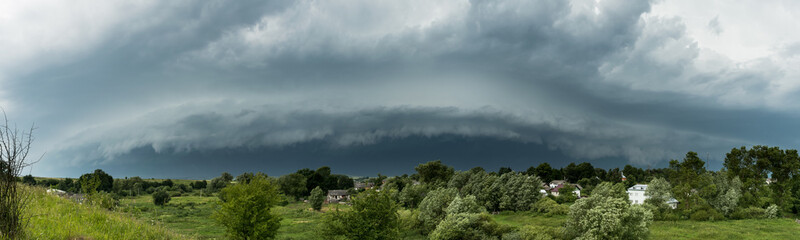 Approaching supercell thunderstorm in the village, panorama of the storm clouds