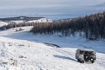 UAZ - Russian Van in prairie with snow-capped mountains on background at Mongolia