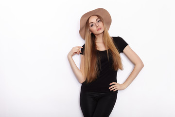 Young beautiful fashion model in women black t-shirt trendy hat posing in studio against white background