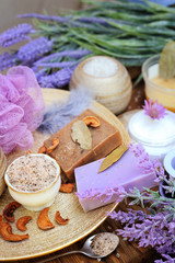 Obraz na płótnie Canvas Natural cosmetics concept background - coffee and lavender artisan soap, salt scrub, cream and flowers