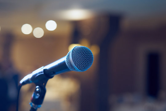 Microphone in concert hall or conference room with defocused bokeh lights in background. Extremely shallow dof. : Vintage style and filtered process