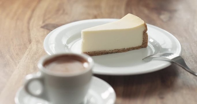 pan shot of espresso and cheesecake on table