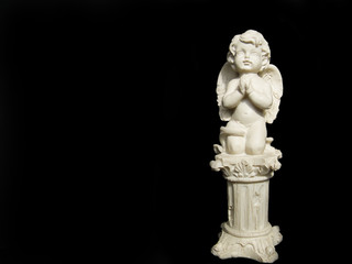 Statuette of an angel on black background