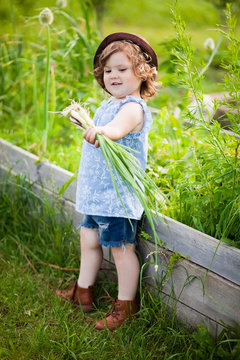 Adorable little girl with onion in the gaden