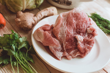 Food ingridients: red beans, carrot, cabbage, meat, onion, ginger for recipe stewed beans with meat on wooden background. Steps in cooking, process of preparing food. Concept of homemade healthy food.