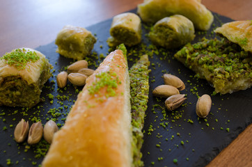 Pistachio and baklava varieties on wooden table