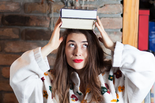 Young Woman Balancing Books On Her Head