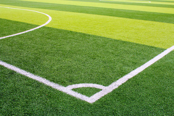 Fototapeta na wymiar Photo of a green synthetic grass sports field with white line shot from above.