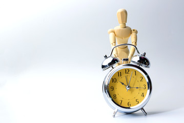 Wooden figure doll try to operate vintage clock on white for save time and money concept