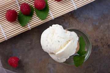 Top view vanilla ice cream in waffle cone with mint leaves on a brown marble background