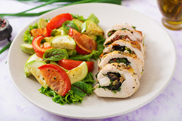 Baked chicken rolls with greens and olives, and baked vegetables - zucchini and tomatoes.