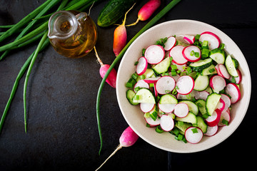 Fresh salad of cucumbers, radishes and green onion. Flat lay. Top view