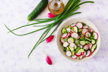 Fresh salad of cucumbers, radishes and green onion. Flat lay. Top view