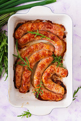 Homemade sausages baked in the oven and herbs. Flat lay. Top view