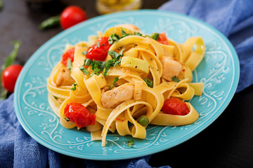 Pasta Fettuccine with tomato, zucchini and chicken fillet in bowl.