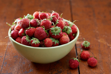 Bowl with fresh strawberry on wooden table
