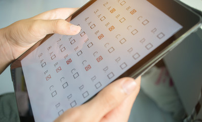 blurred of student testing in online exam in form exercise, exams answer on tablet with...
