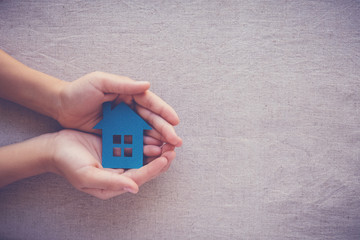 Adult and child hands holding paper house, family home, homeless shelter, foster home care, family...