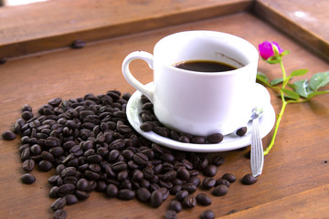Coffee cup and coffee beans on wooden background.