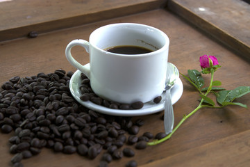 Coffee cup and coffee beans on wooden background.