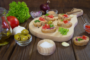 Sandwiches with tuna pate and various attachments on wooden board