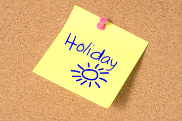 Eine Pinnwand und ein Memo Zettel mit dem Wort Urlaub