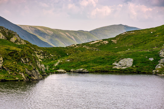 lake in mountains with grass on hillside