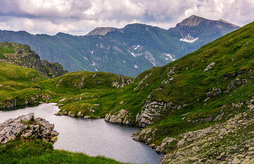 Fototapeta na wymiar lake in mountains with grass on hillside