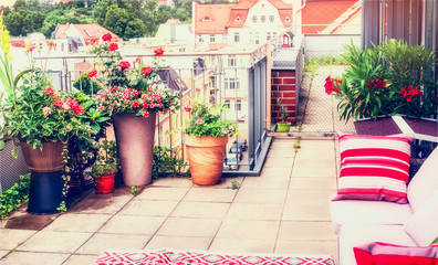 Fototapeta na wymiar Balcony or terrace patio design with comfortable rattan furniture and patio flowers pots. Urban lifestyle