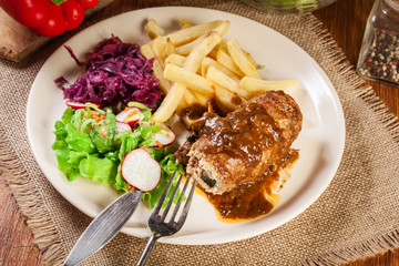 Pork roulade with french fries with salad
