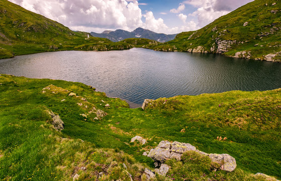 lake in mountains with grass on hillside