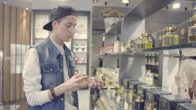 Young man choosing perfume in a beauty store