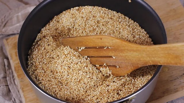 Sesame seeds in rustic wooden bowl turning on sackcloth Background. HD