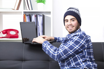 Young man hipster in the office with laptop in the office