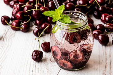 detox water with cherry on white wooden background. Healthy drink