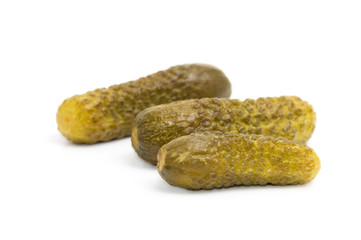 Three marinated pickled cucumbers isolated on white background