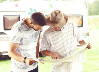 Good friends checking the map and planning their route. Trip, traveling, holiday, vacation concept.