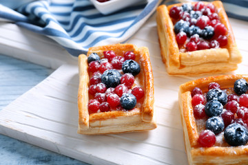 Delicious pastries on white wooden cutting board