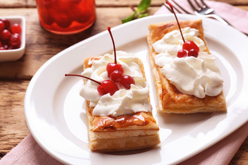 Tasty puff pastry dessert with berries and whipped cream on plate