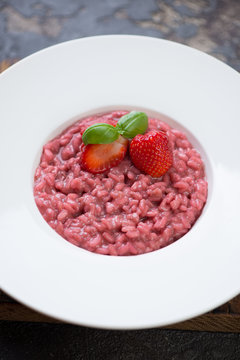 Close-up of strawberry risotto served in a white plate, selective focus, studio shot