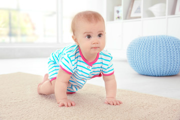Cute little baby crawling on floor at home