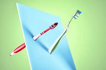 Fine art display of two new plastic toothbrushes