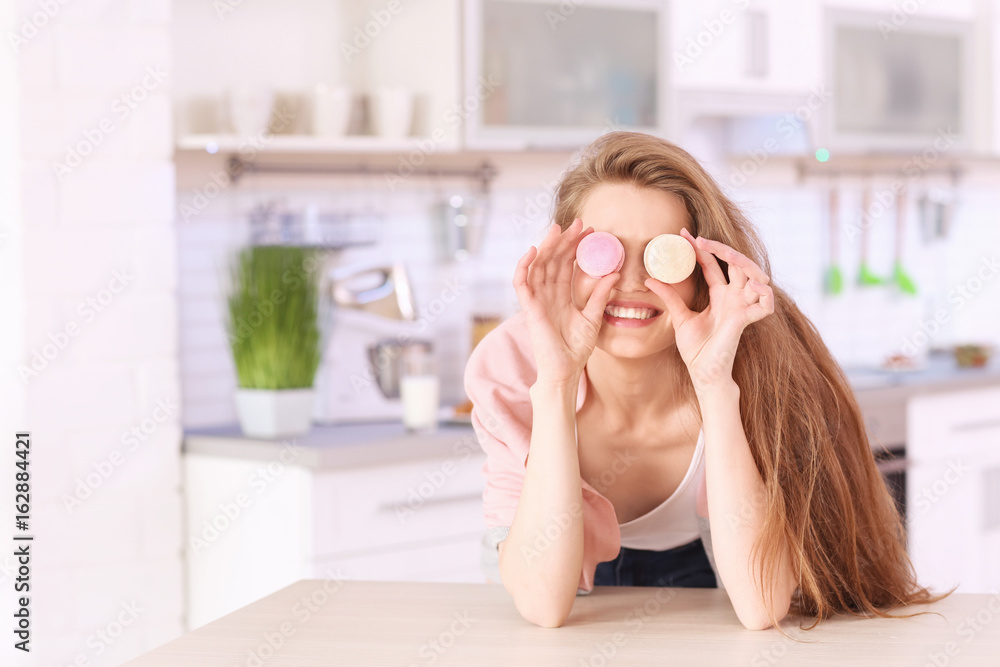 Poster beautiful young woman with macarons in kitchen