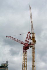 Construction cranes on a street in a big city on cloudy summer day, Frankfurt am Main, Germany.
