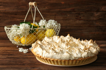 Composition with tasty lemon meringue pie on wooden table