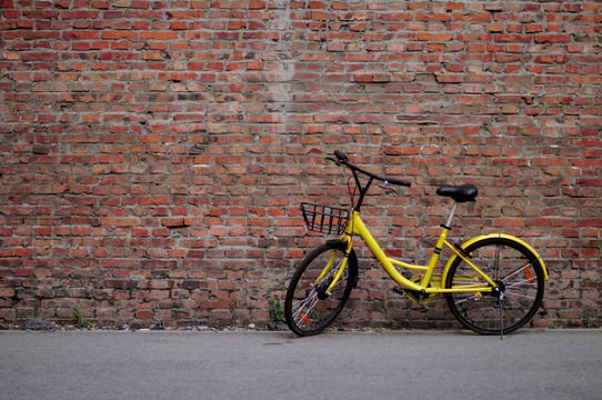 Yellow Bicycle by the Brick Wall
