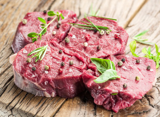 Pieces of beef tenderloin on the wooden cutting board.